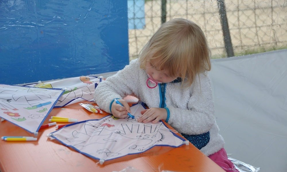 Kind malt einen Spieldrachen in der Kinderecke vom Glöckle Jubiläumsfest aus