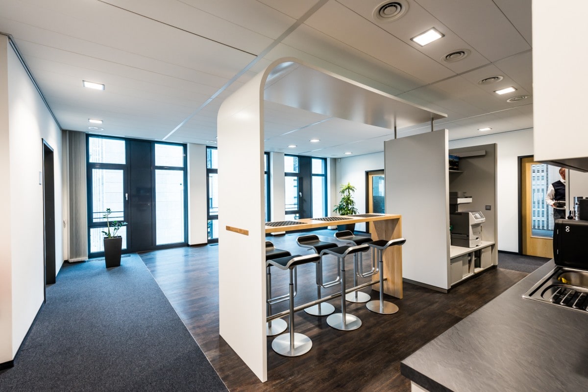 Aufenthaltsraum mit kleiner Küche und Sitzplätzen für Mitarbeiter im neuen Bürogebäude