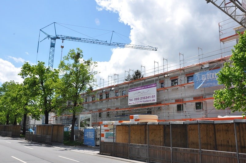 Blauer Glöckle-Baukran ragt über dem Rohbau der neuen Wohnanlage in Nürnberg