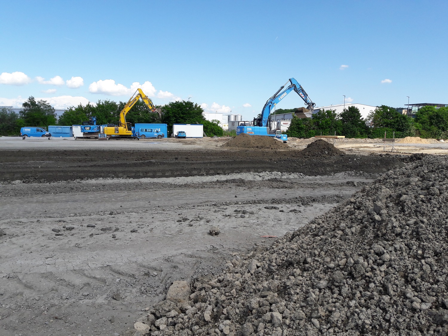 Mehrere Glöckle-Bagger, Raupen, Walzen sind mit der Erneuerung der Außenanlagen beschäftigt
